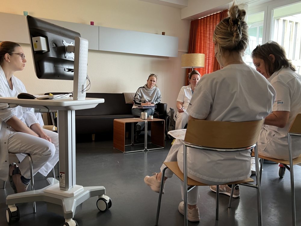 Palliaviva-Mitarbeiterin Heike Hess (in der Mitte, auf dem Sofa) nimmt regelmässig am interdisziplinären Rapport der Palliativstation des Spitals Männedorf teil.