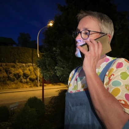 Palliaviva-Mitarbeiterin Ankie van Es steht in der Nacht auf einem Trottoir und telefoniert.