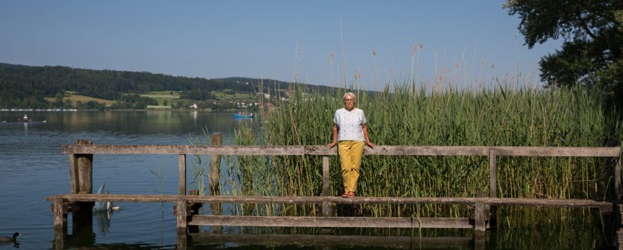 Ruth Nievergelt, Angehörige eines Palliaviva-Patienten, steht auf einem Steg an einem See.