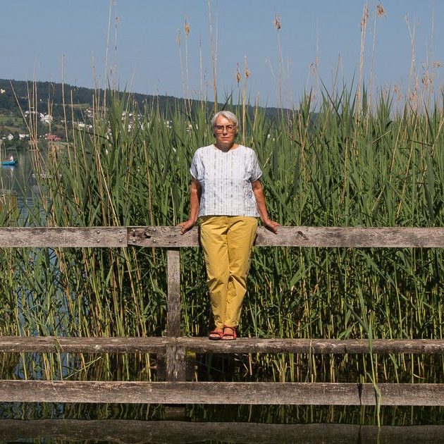 Ruth Nievergelt, Angehörige eines Palliaviva-Patienten, steht auf einem Steg an einem See.