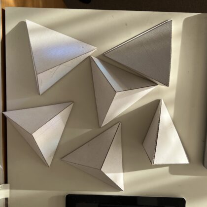 Exakt gearbeitete Kartonobjekte auf dem Arbeitstisch im Atelier.